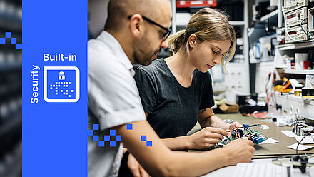 Deux personnes travaillent sur des composants électroniques dans un atelier, avec LANCOM Built-in Security à gauche.