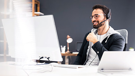 Photo d'un participant au webinaire avec un casque devant son ordinateur.