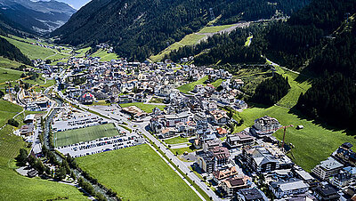 Photo de la commune d'Ischgl prise d'en haut par avion : Maisons et rues idylliques dans la vallée entre les montagnes