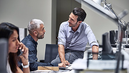 Des collaborateurs discutent à un bureau